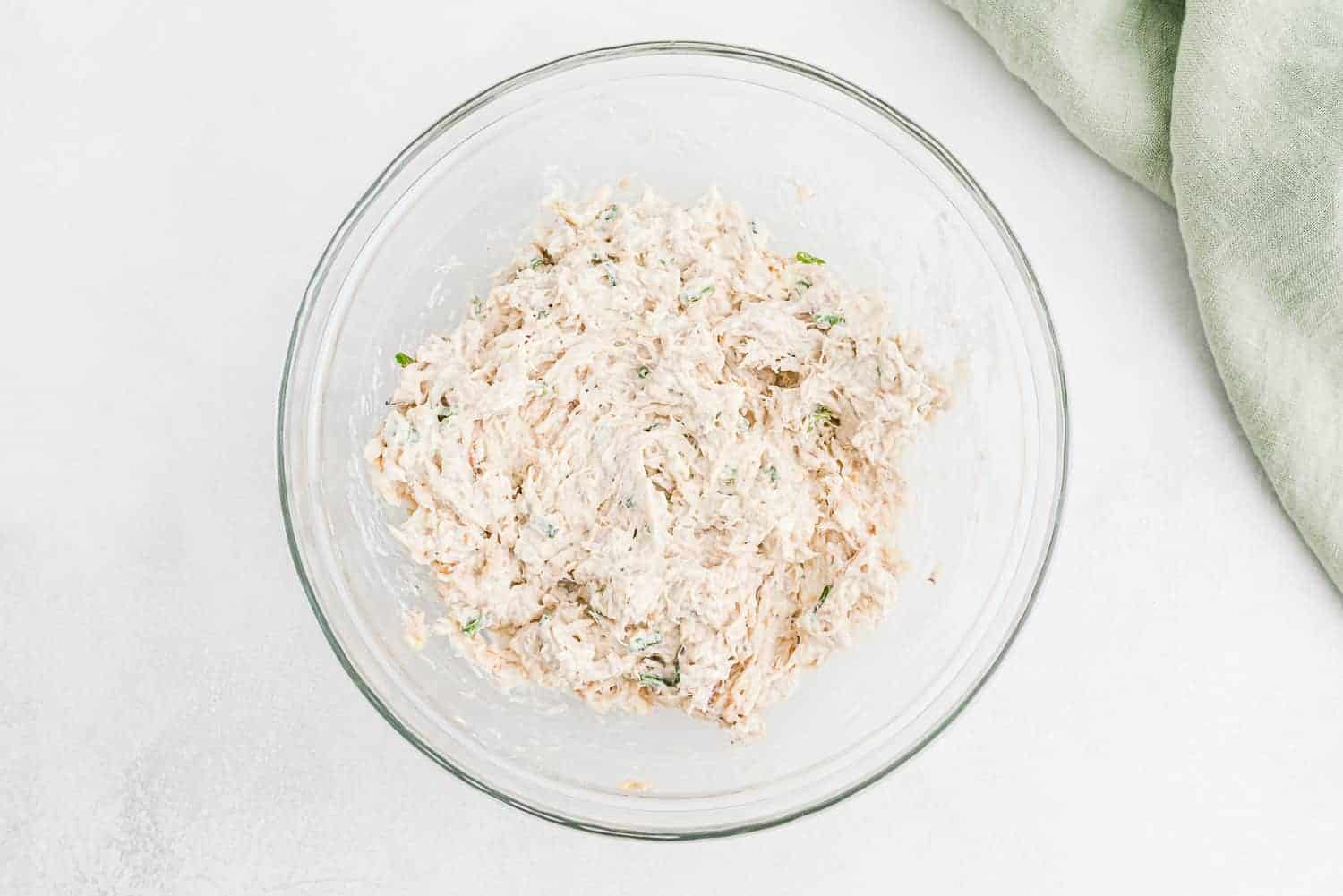 Crab filling in a clear glass mixing bowl.