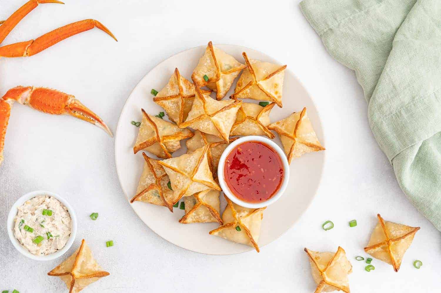 Plate of crab rangoon with sweet chili sauce.