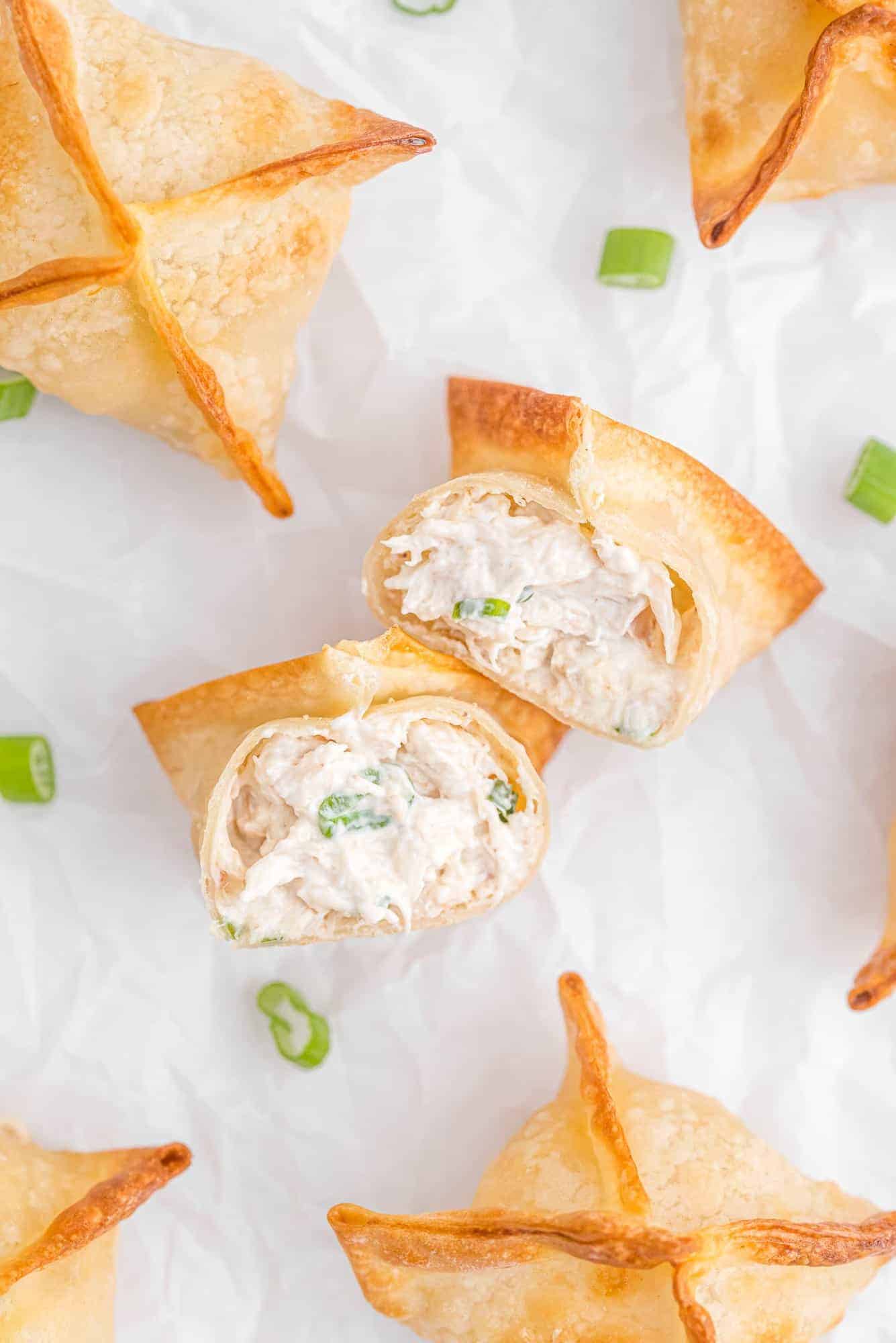 Overhead view of crab wontons with green onions.