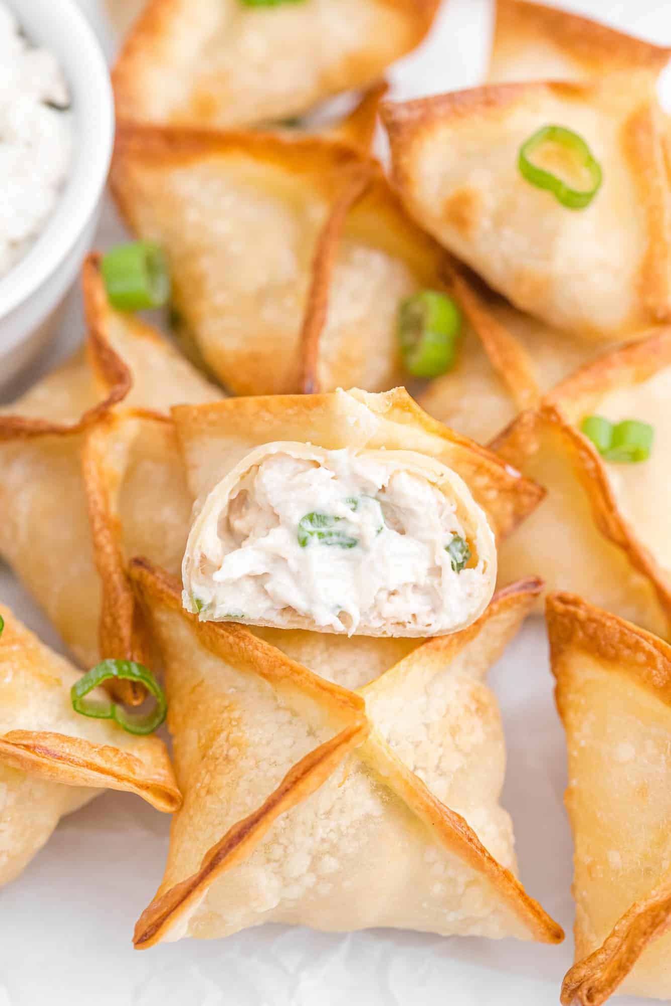 Crab rangoon on a plate with green onions