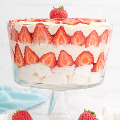 Layered strawberry trifle in a clear glass trifle bowl.