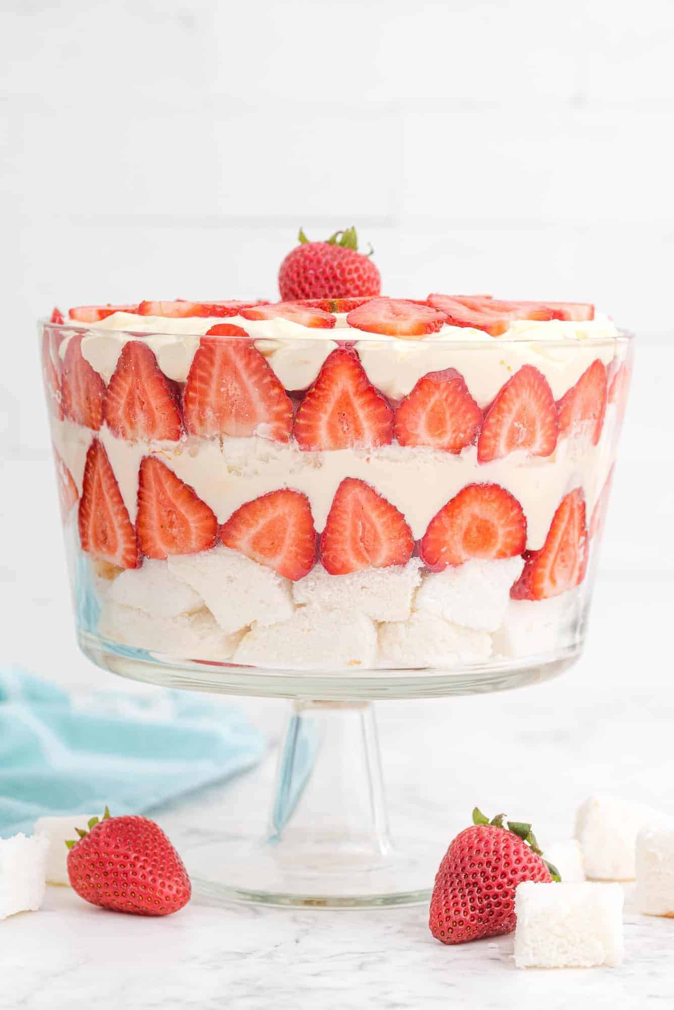 Strawberry trifle in clear glass trifle bowl against white background.