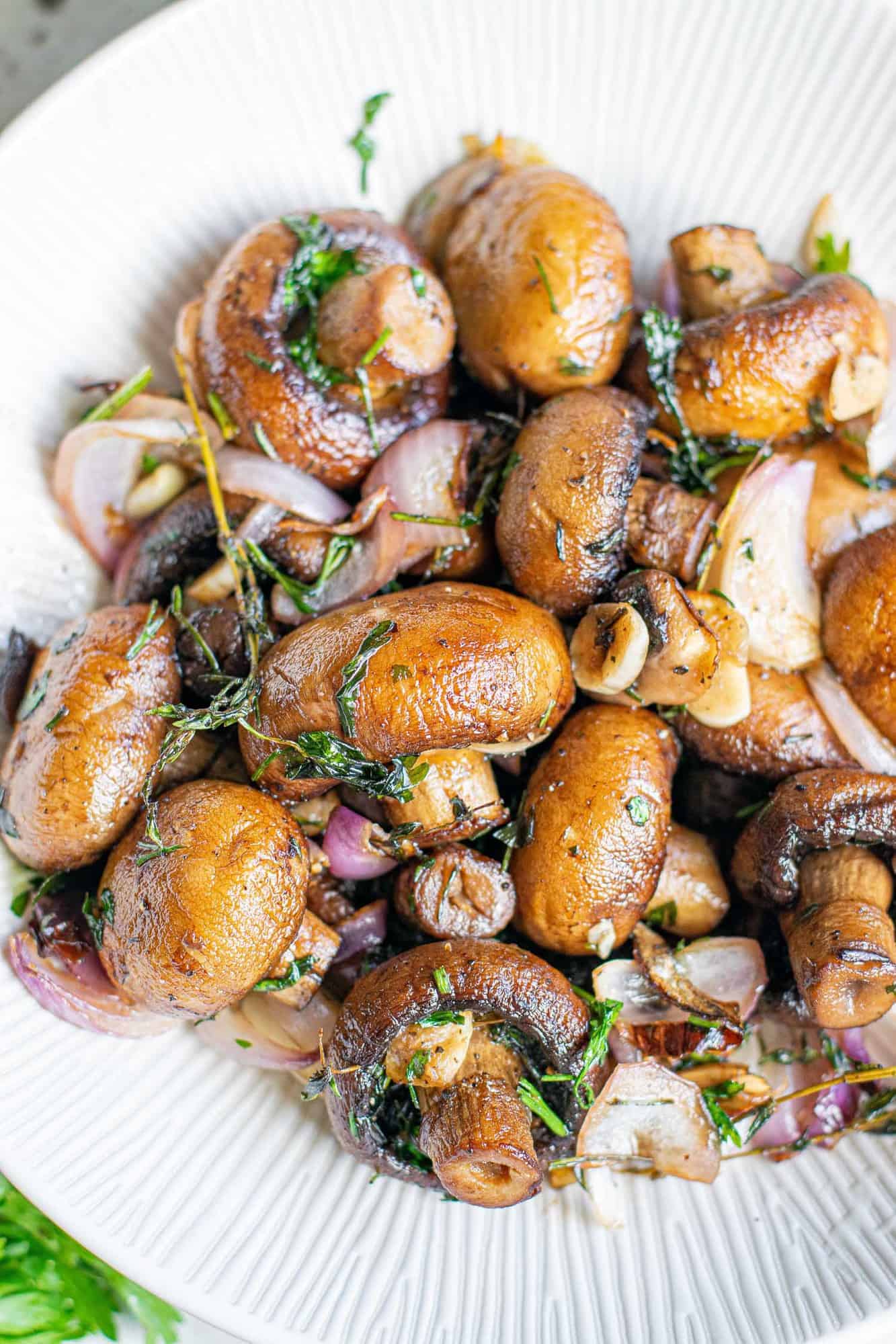 Golden brown cooked mushrooms in a white bowl.