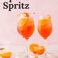 An orange drink in a wine glass, with a text overlay that reads "the best aperol spritz."