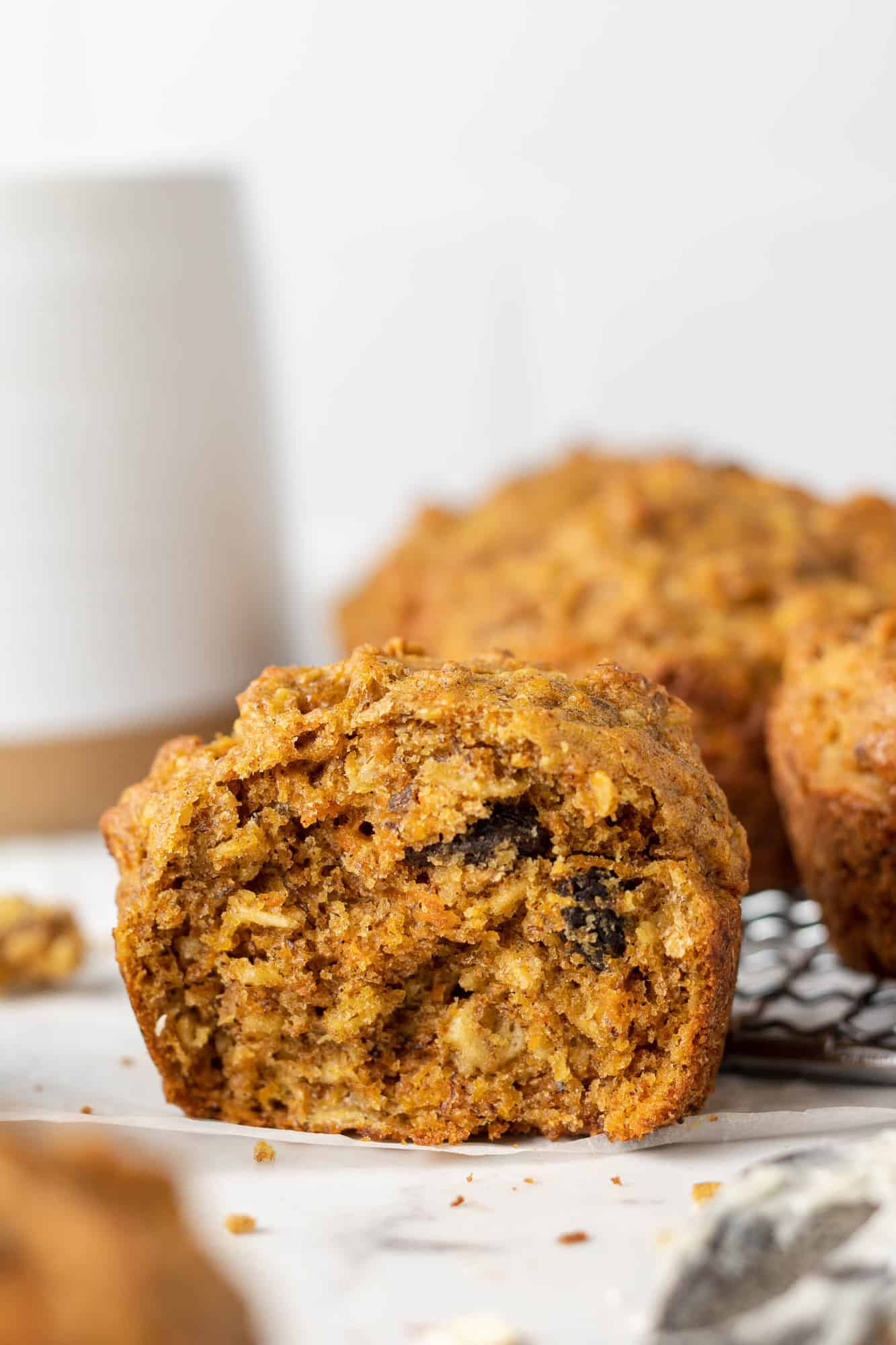 Muffin torn in half to show interior: carrots, oats, and raisins are visible.