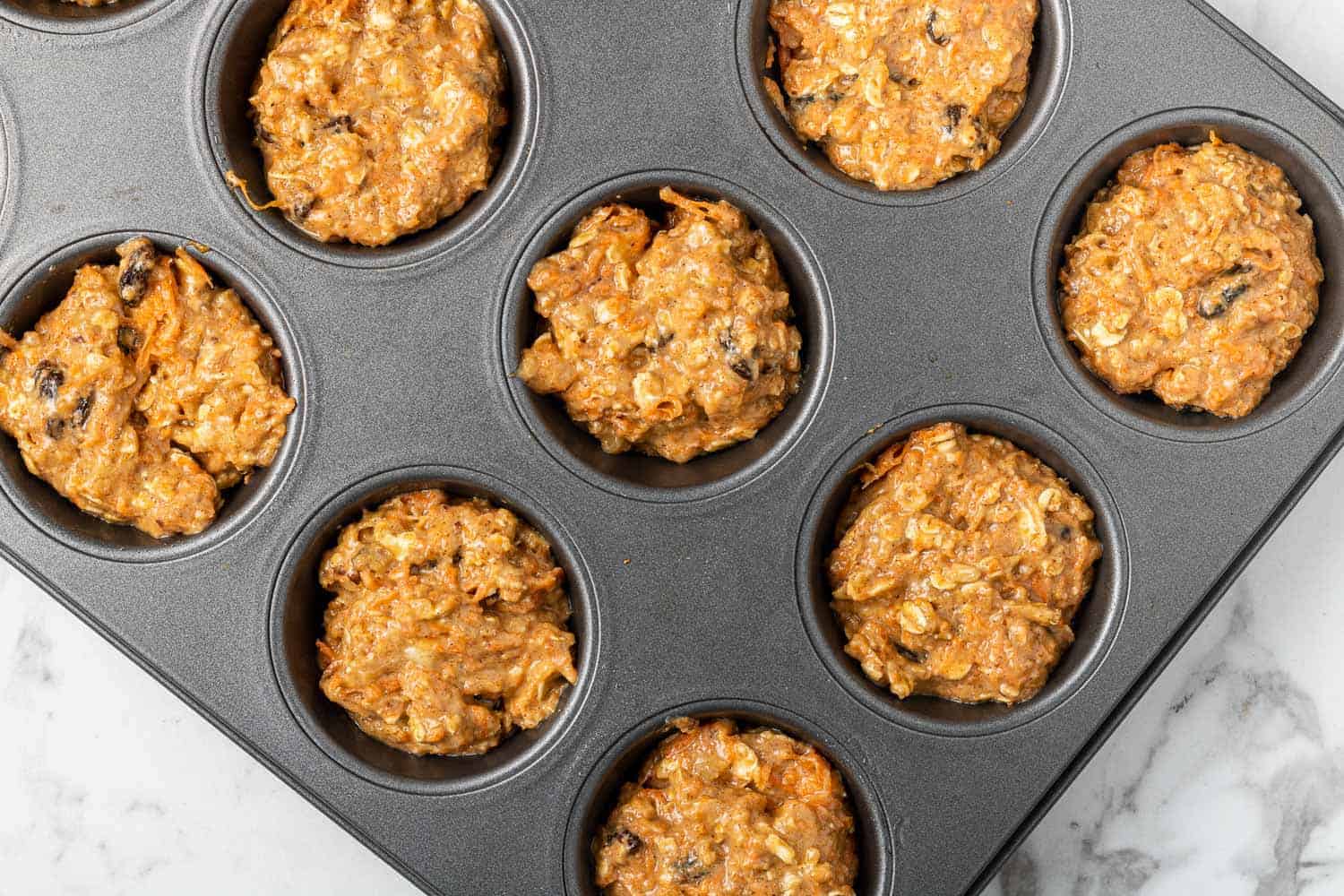 Unbaked muffins in a muffin tin.