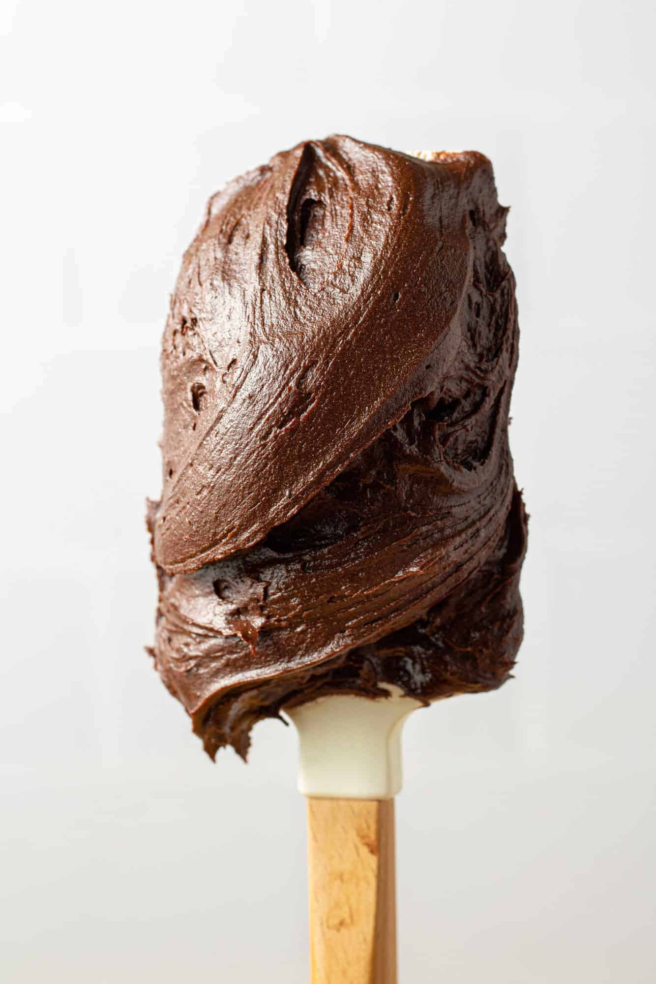 Frosting on a wooden handled white spatula. 