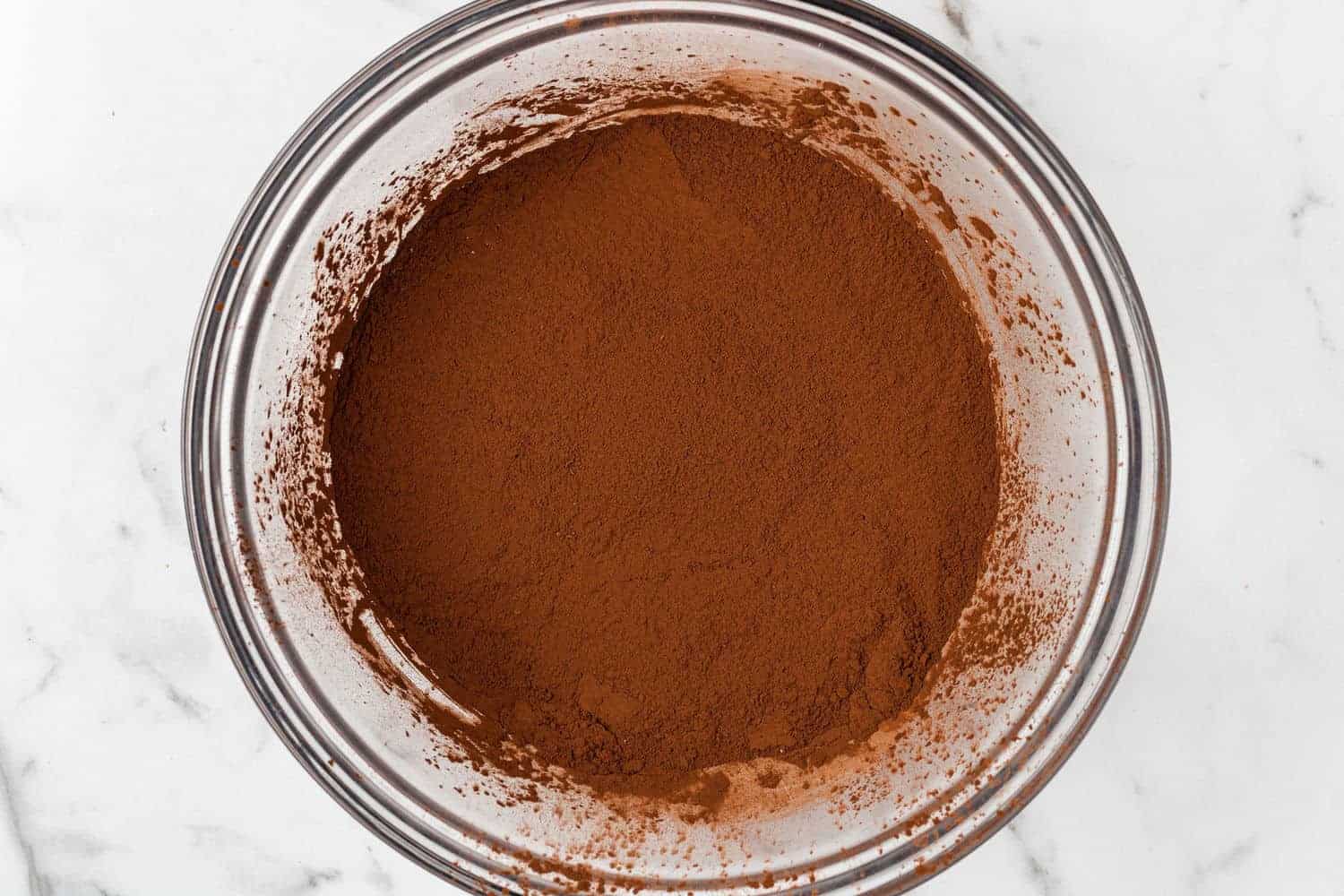 Cocoa powder in a glass mixing bowl.