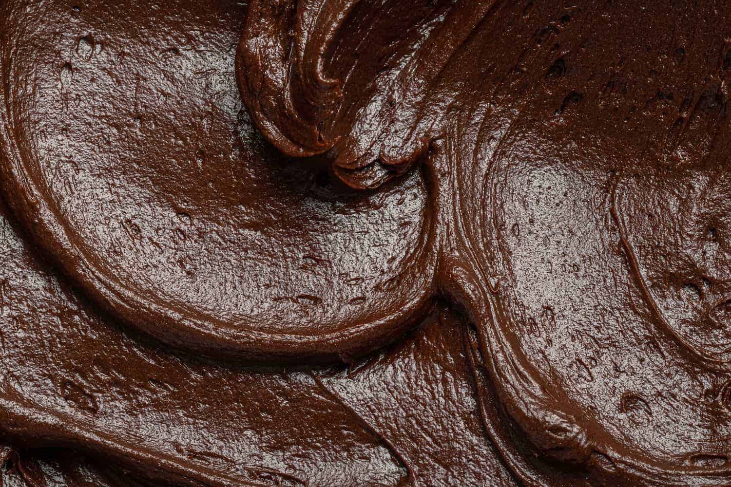 Close up of chocolate frosting with swirls.