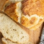 Overhead view of a partially sliced loaf of bread.