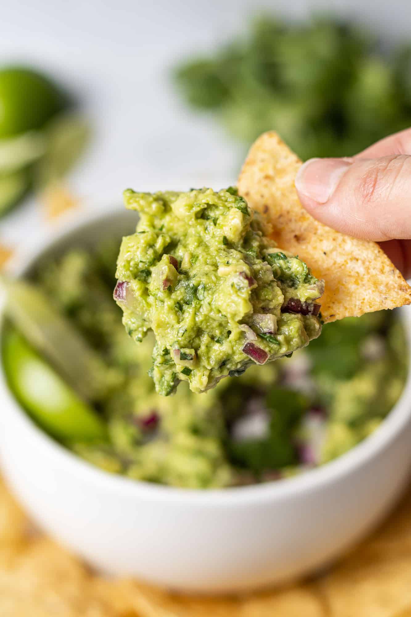 Guacamole on a chip held in a hand.