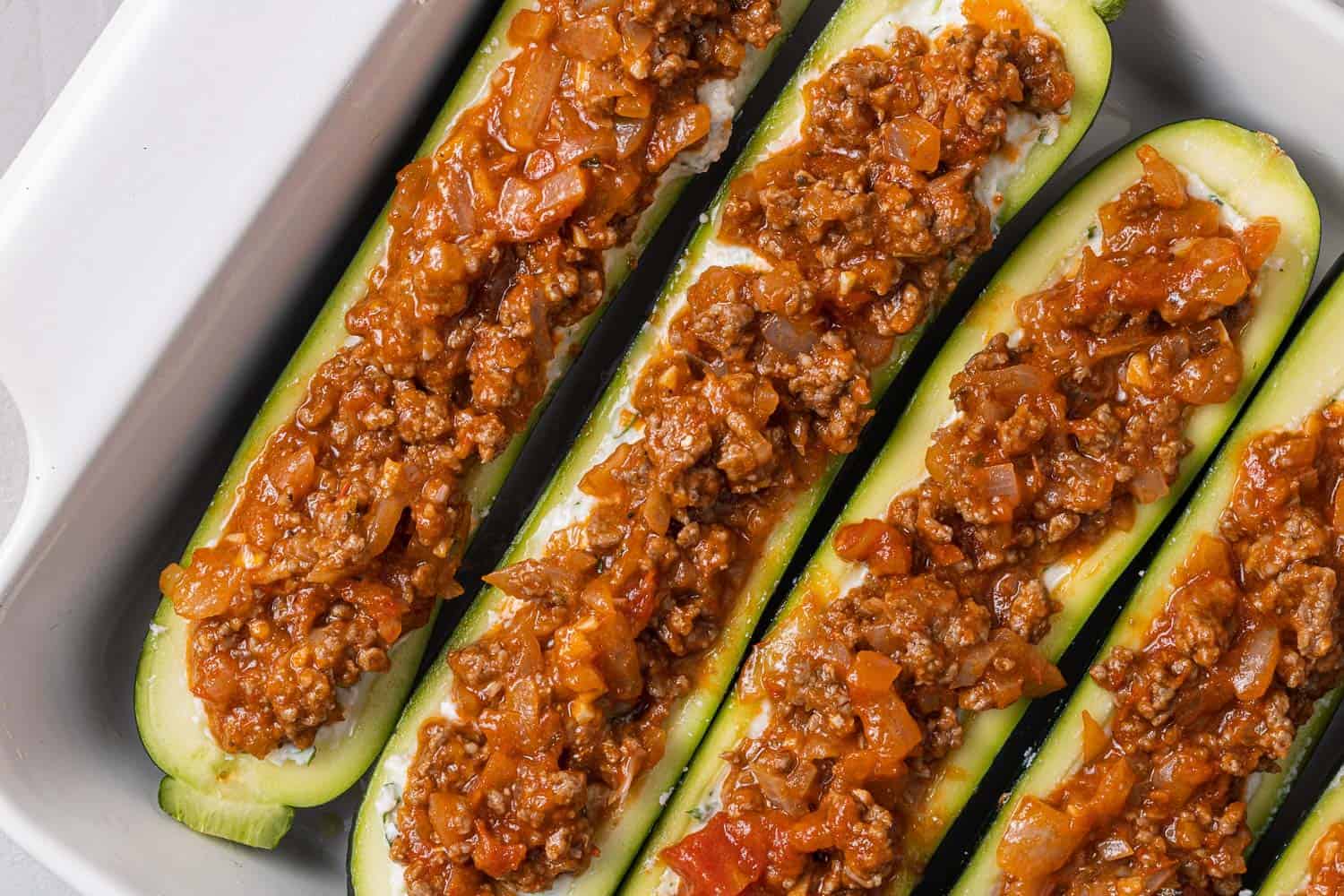 Zucchini boats topped with meat sauce.