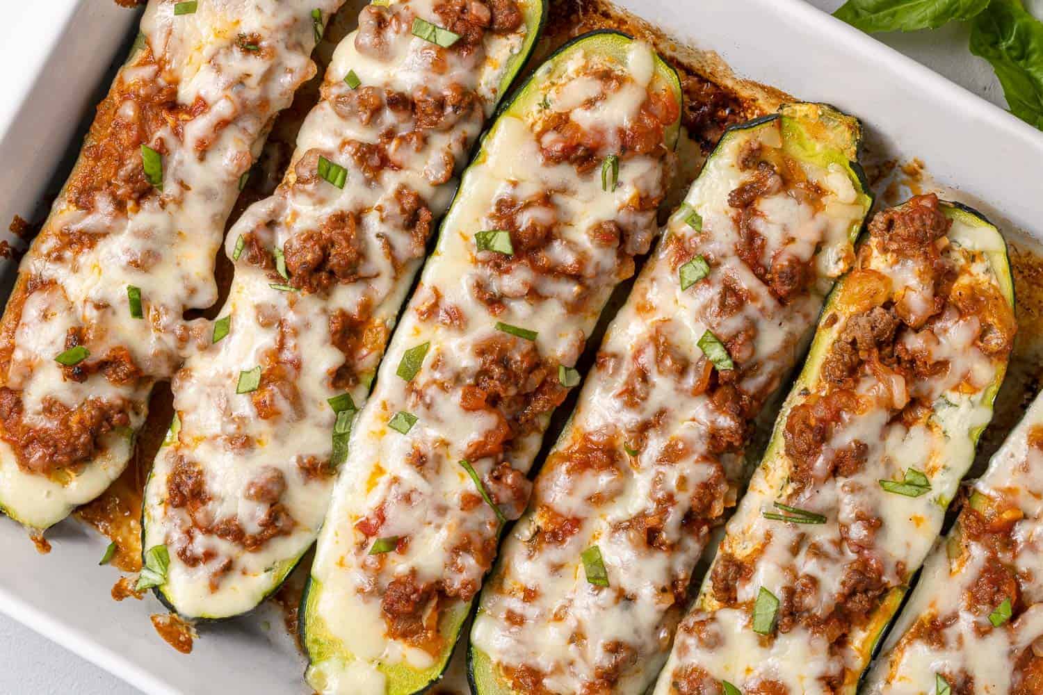 Stuffed zucchini topped with meat sauce and cheese.