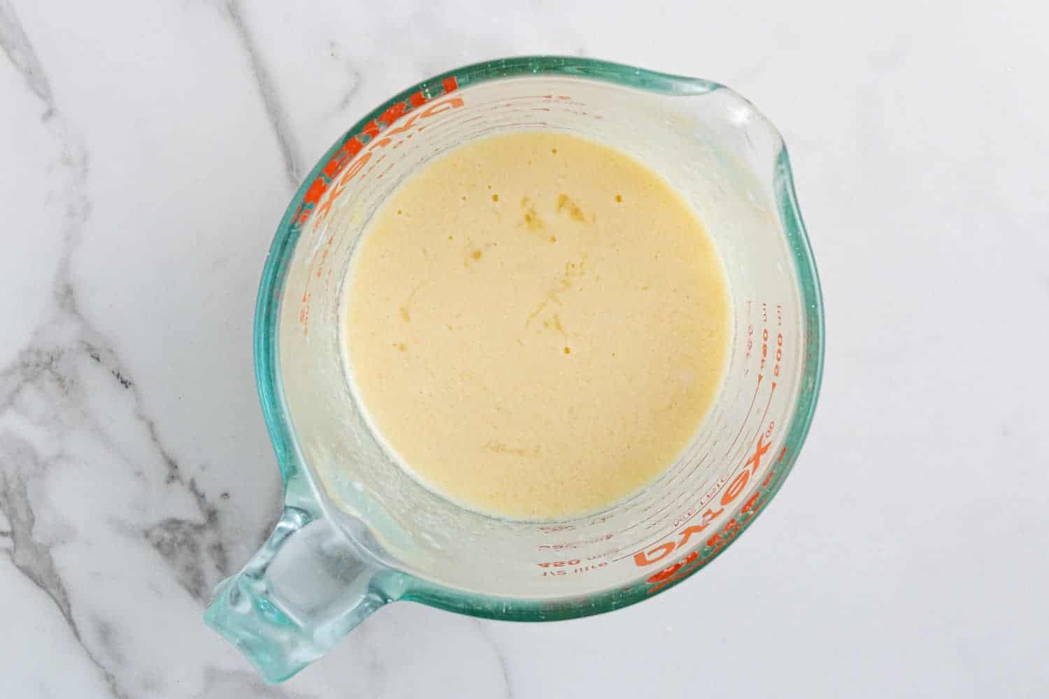 Eggs and buttermilk in a glass measuring cup.