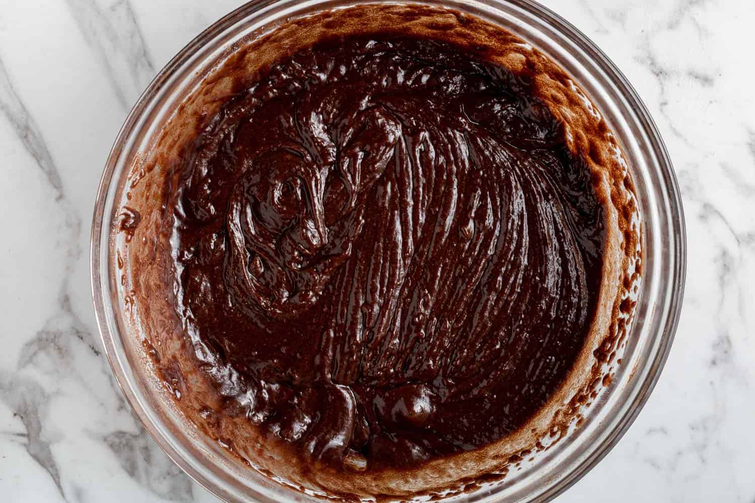 Cake batter in a clear glass mixing bowl.