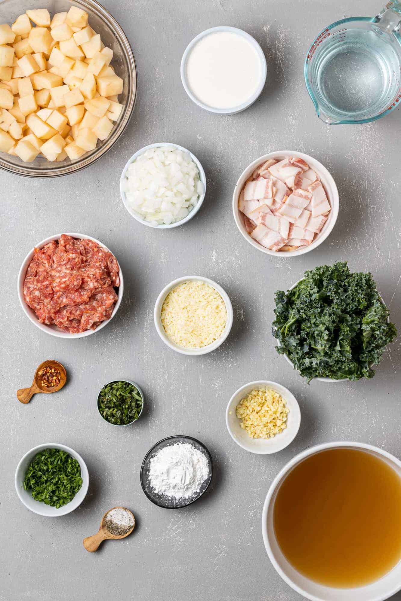 Overhead view of ingredients needed for recipe: sausage, potatoes, kale, and more.