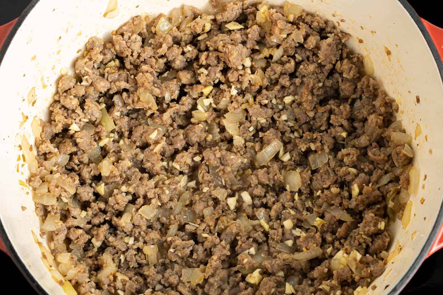 Browned sausage crumbles mixed with onions and garlic.