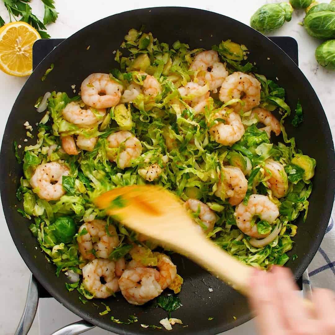 Shrimp and brussels sprouts in a skillet.