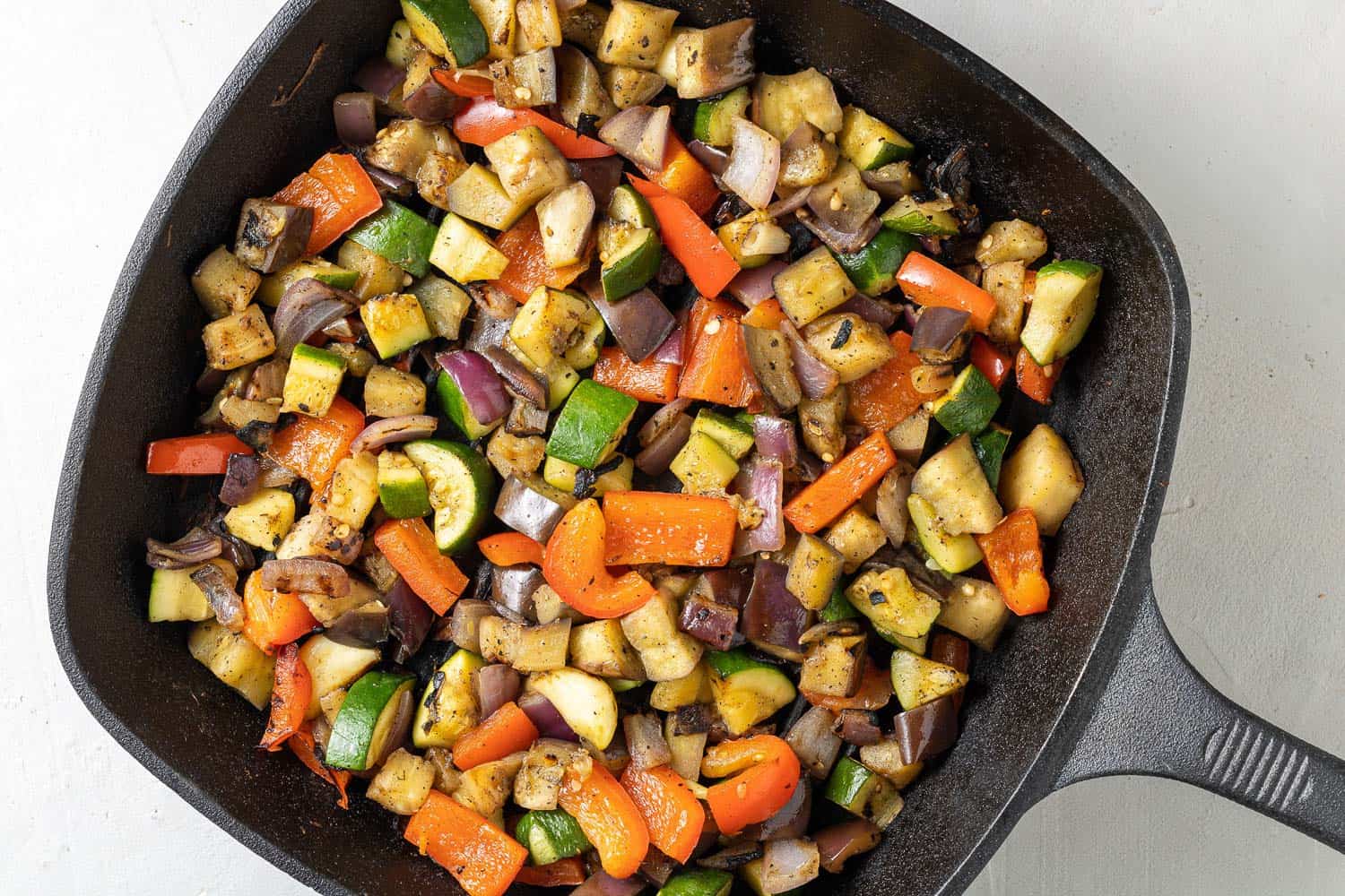 Cubed vegetables being grilled in a grill pan.