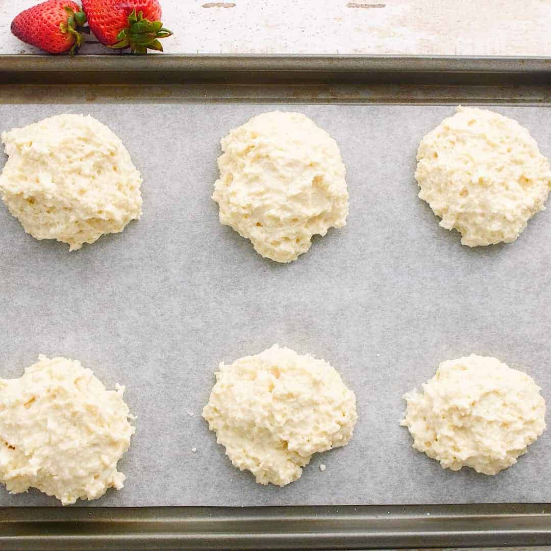 Unbaked shortcakes on a tray.