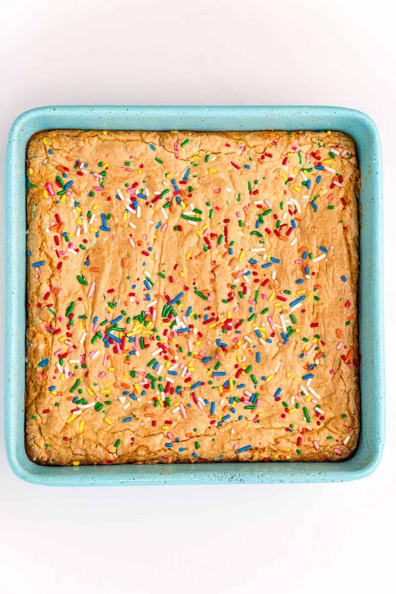 Baked blondies in a bright blue baking dish.