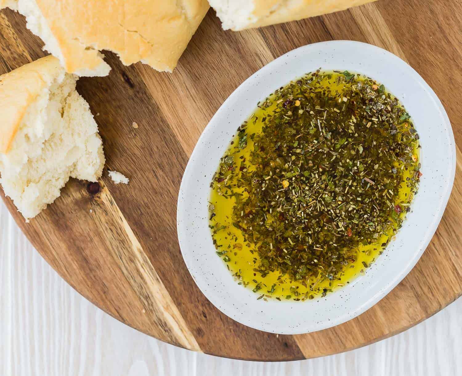 Overhead view of bread dipping oil and bread on a wooden surface.