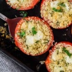Overhead view of stuffed tomatoes in a black dish.