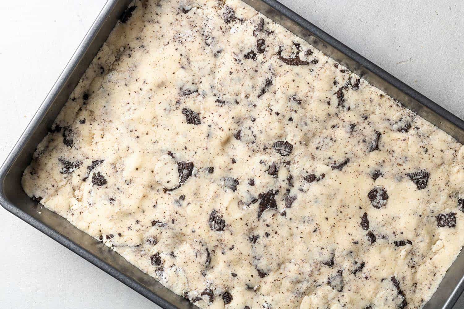 Unbaked cookie dough in a 9x13 baking dish.