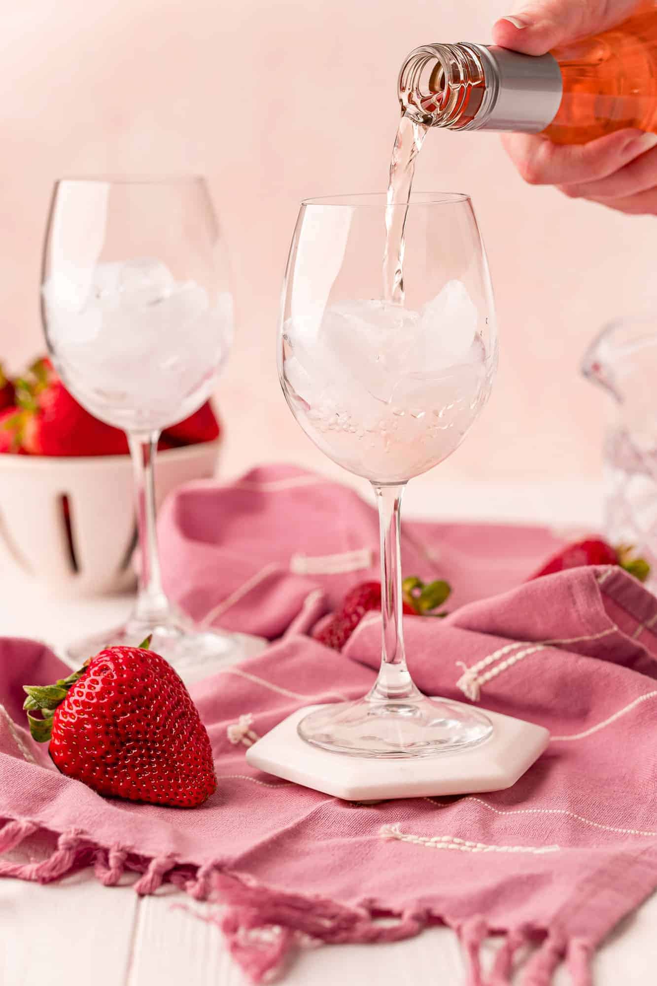 Rose being poured into a glass with ice.