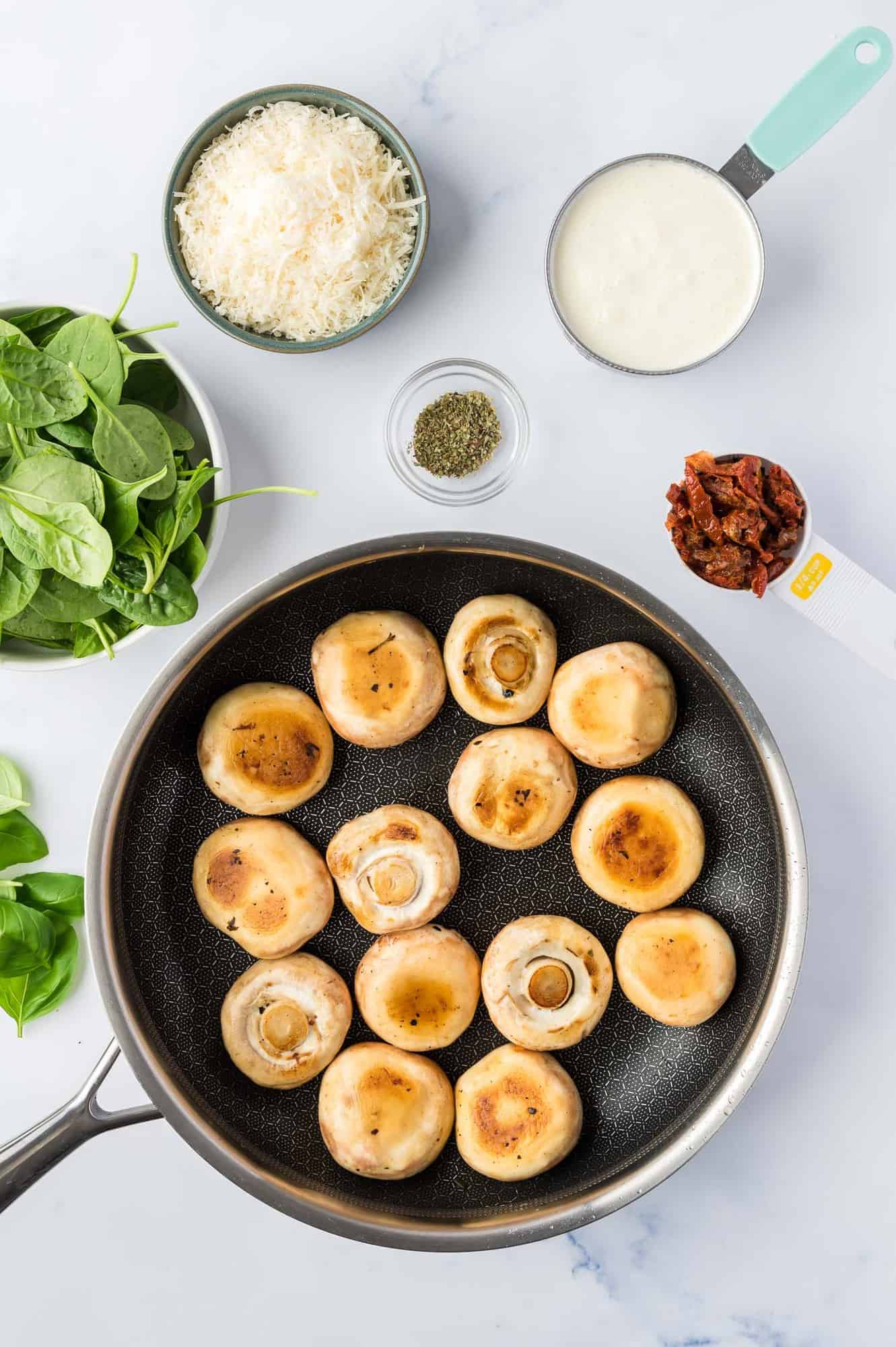 Browned whole mushrooms in a black skillet.