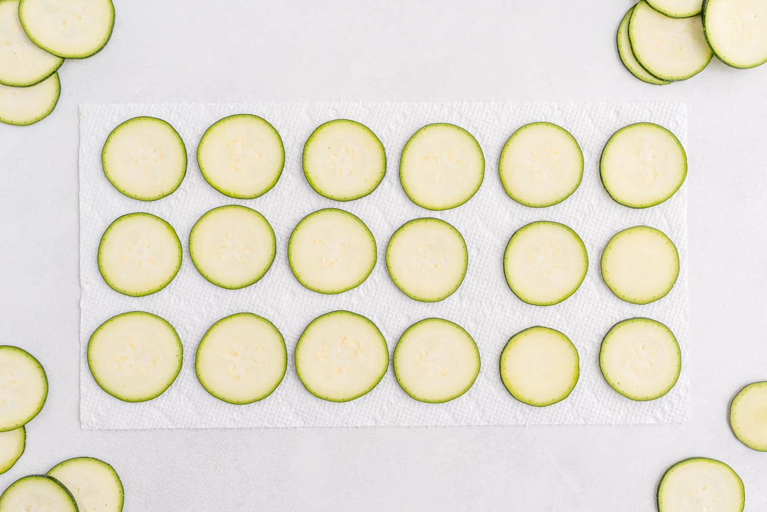 Zucchini slices laid out on a paper towel.