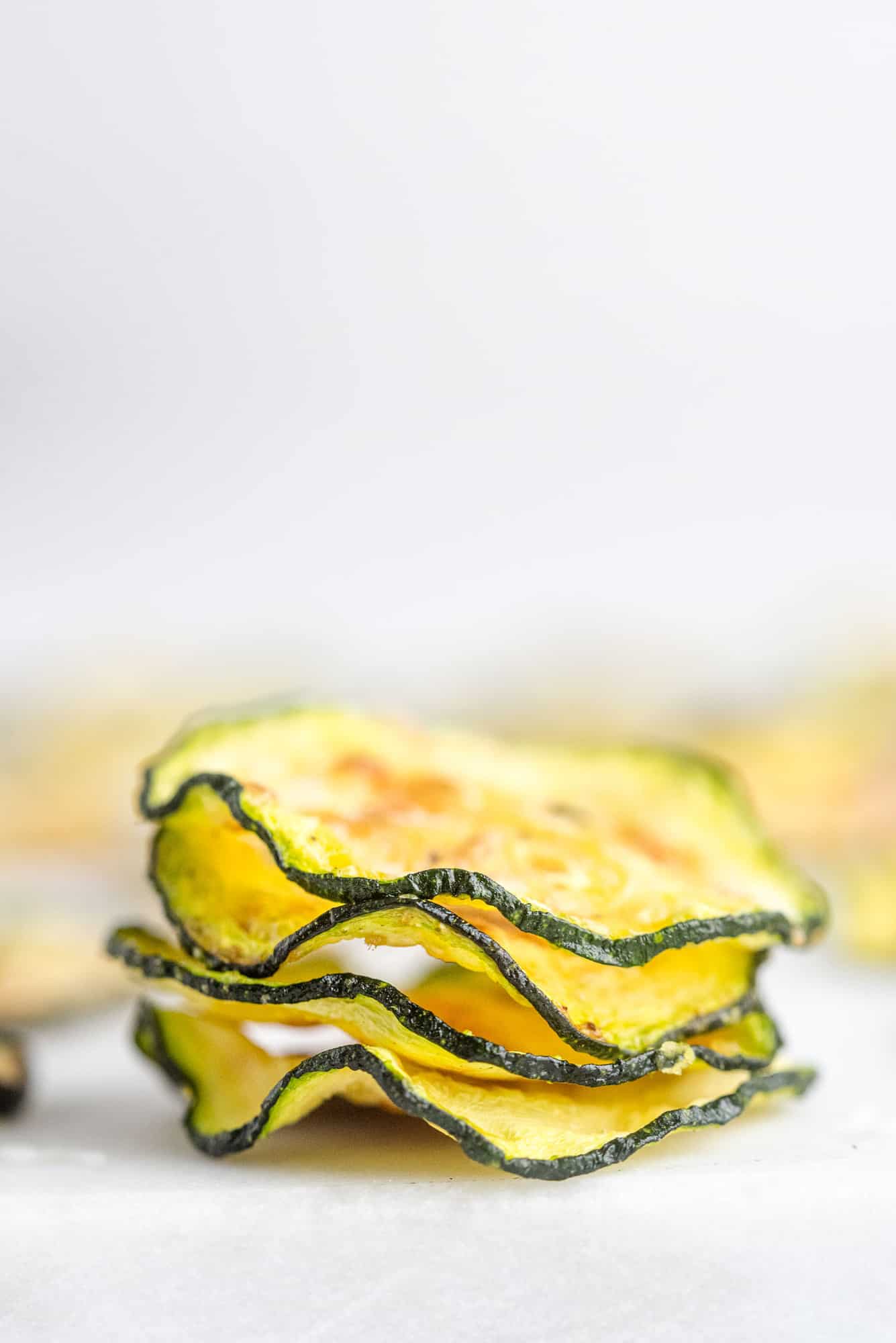 Stacked up zucchini chips, showing crispy texture.