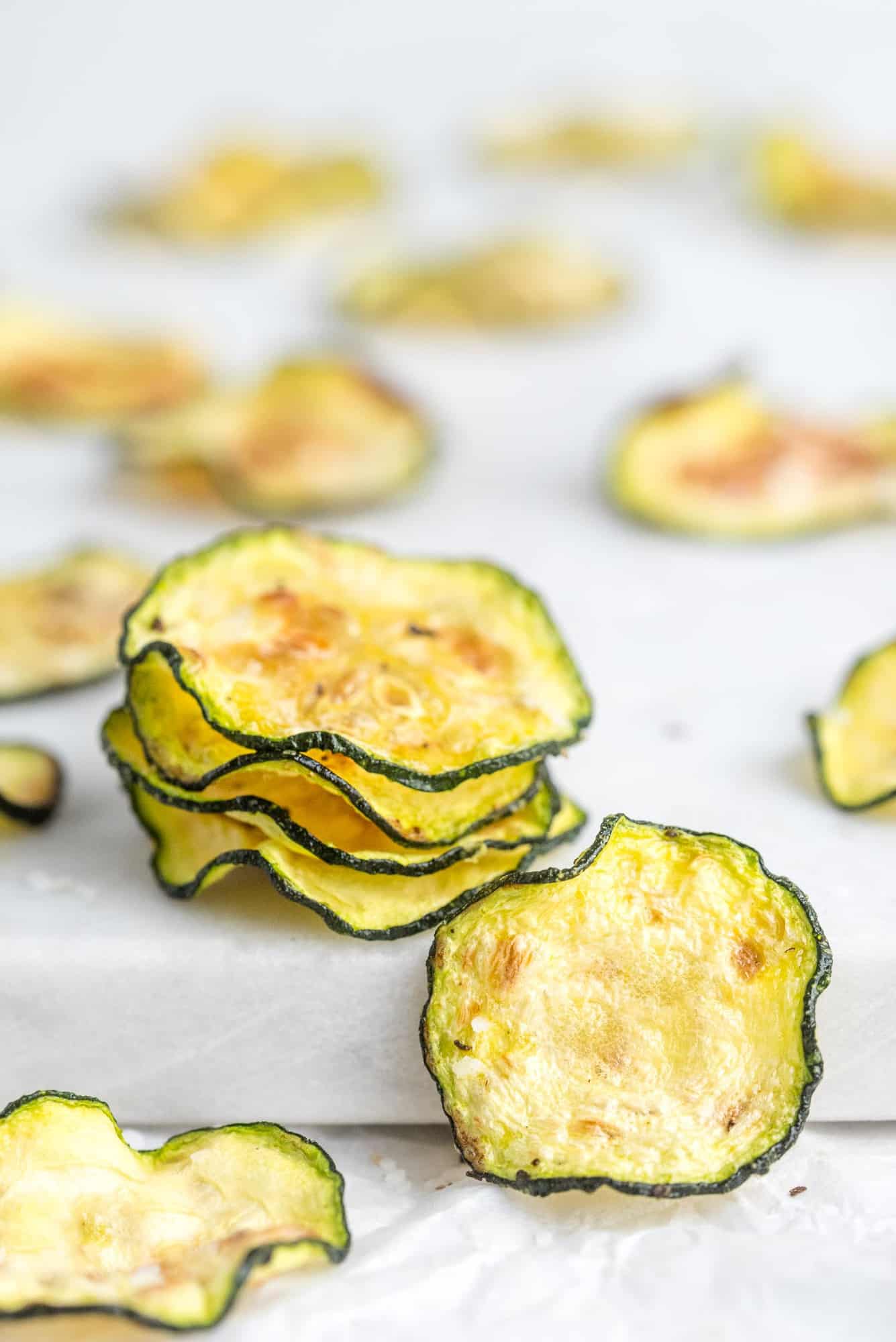 Thinly sliced, cooked zucchini on a white background.