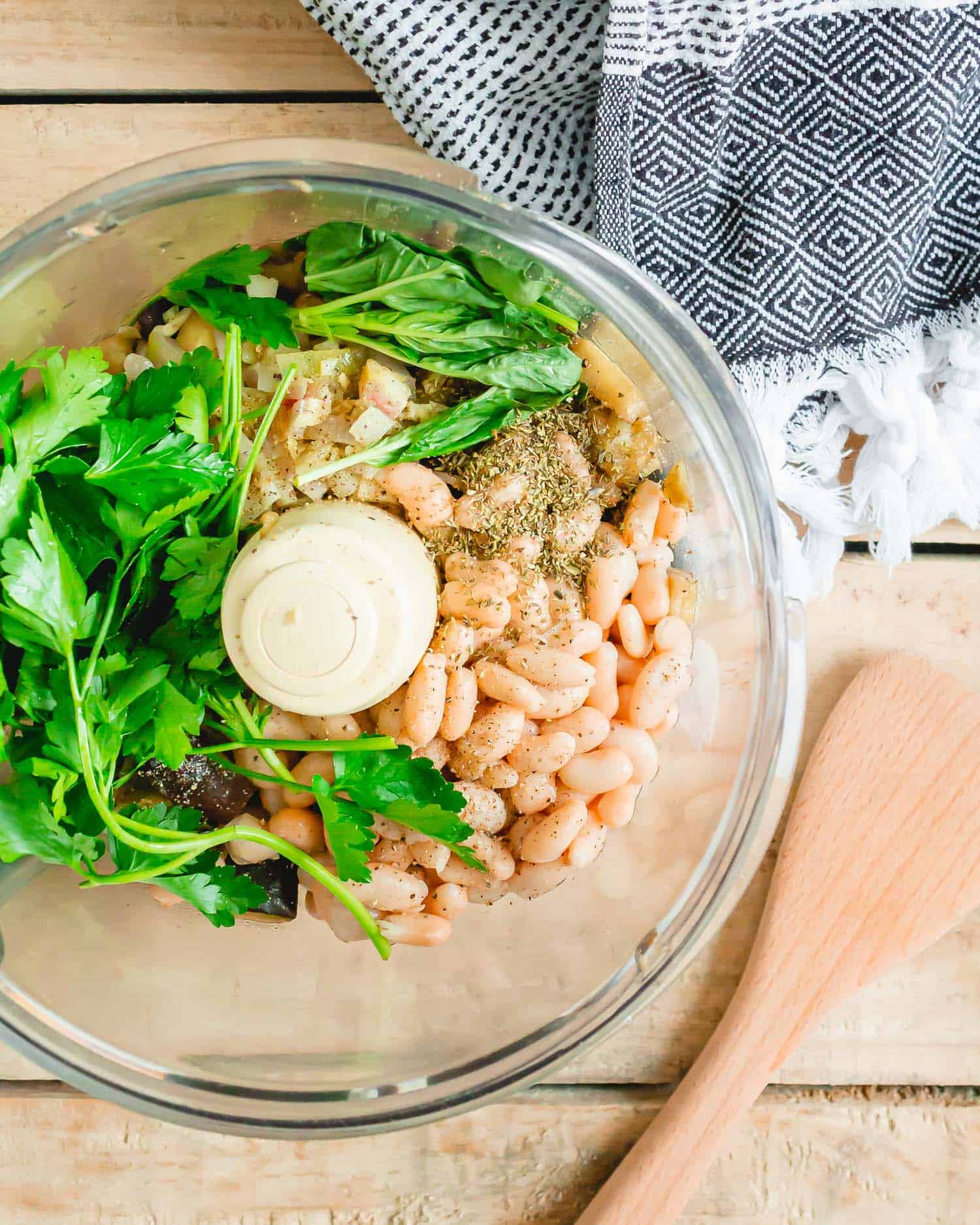 Beans, herbs, and sautéed eggplant in a food processor.