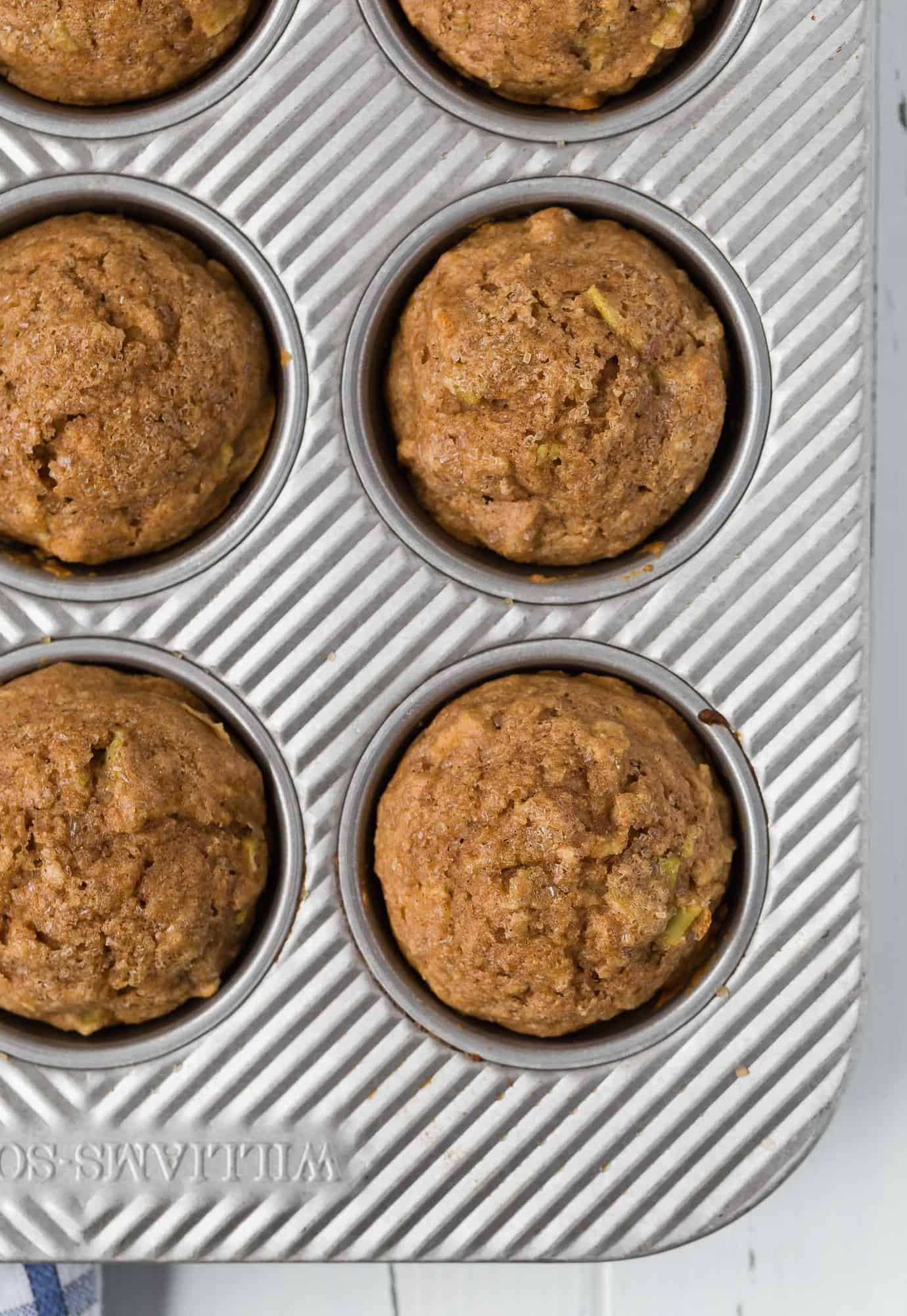 Overhead image of apple cinnamon muffins in a muffin tin.