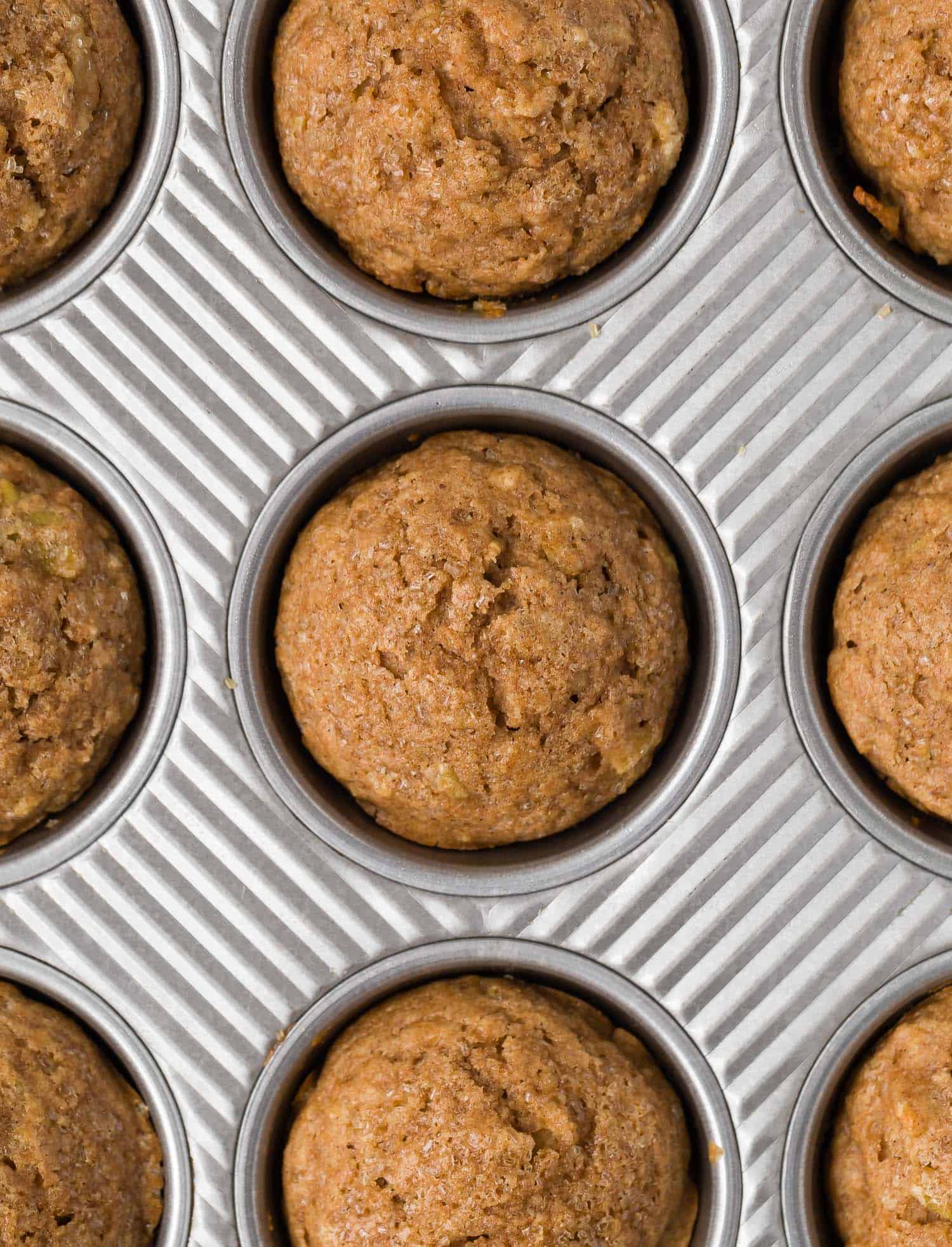 Overhead view of apple cinnamon muffins in a muffin tin.