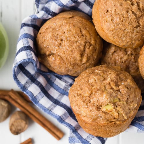 Overhead view of muffins in a basket with blue and white linen.