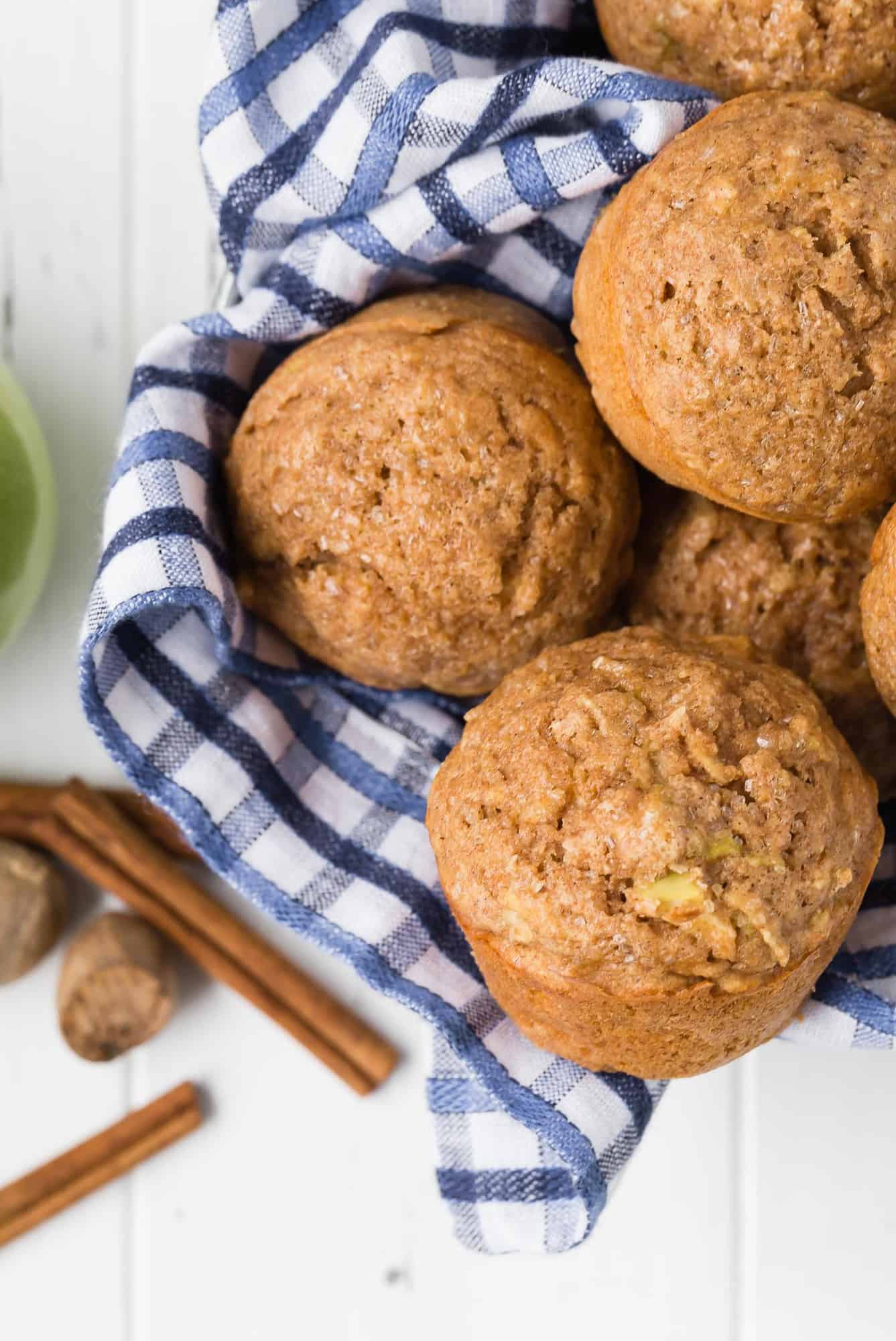 Overhead view of muffins in a basket with blue and white linen.