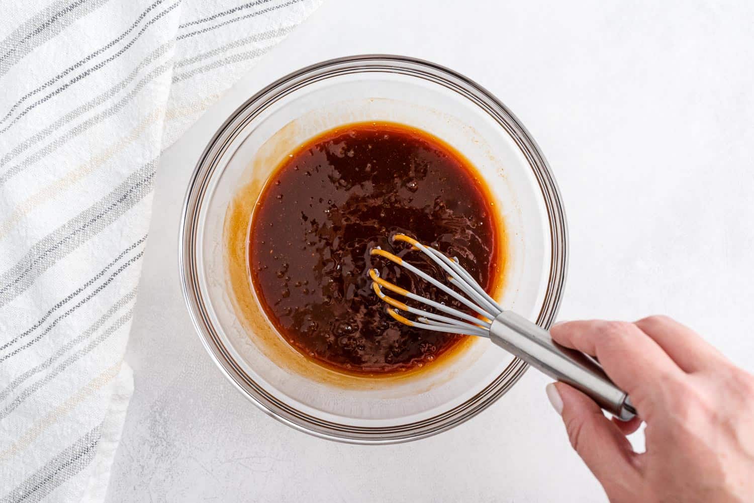 Sauce being whisked together in a small glass bowl.