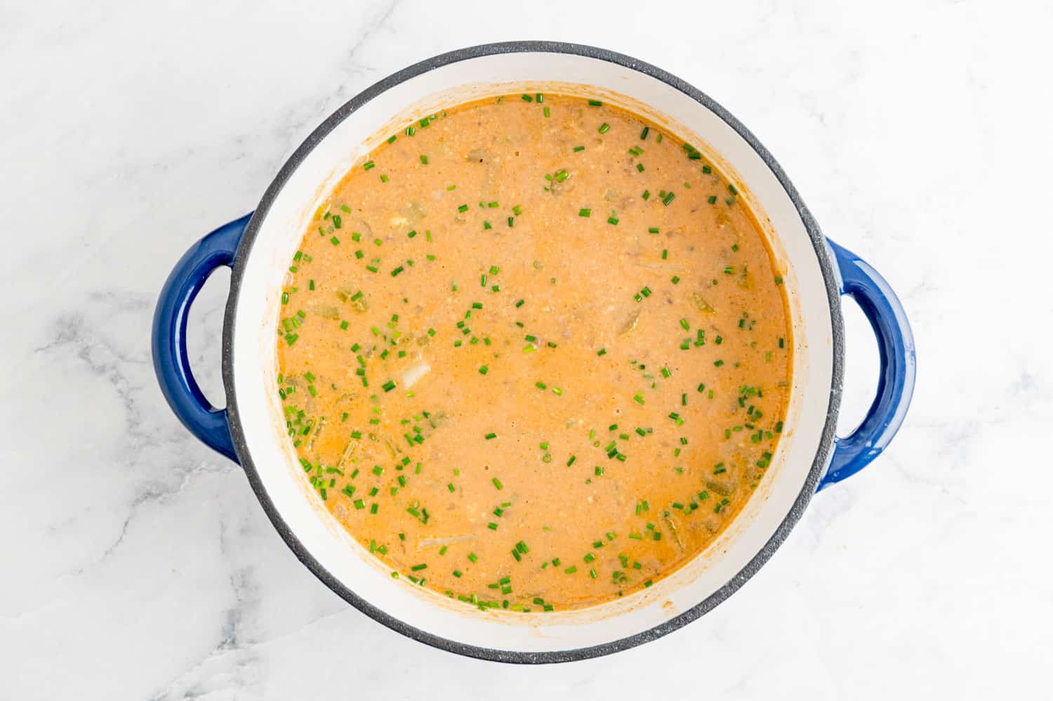 Chives in a creamy tomato, beef, potato soup.