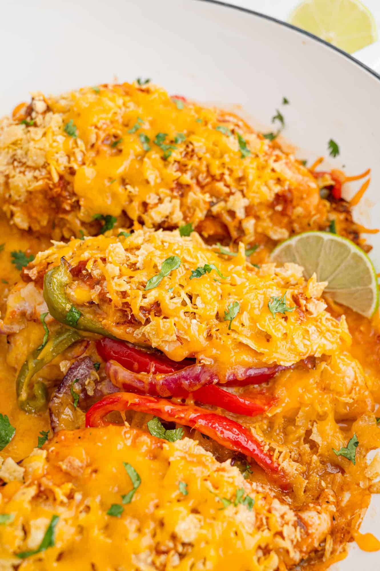 Chicken stuffed with peppers and onions and topped with crushed chips and cheese.