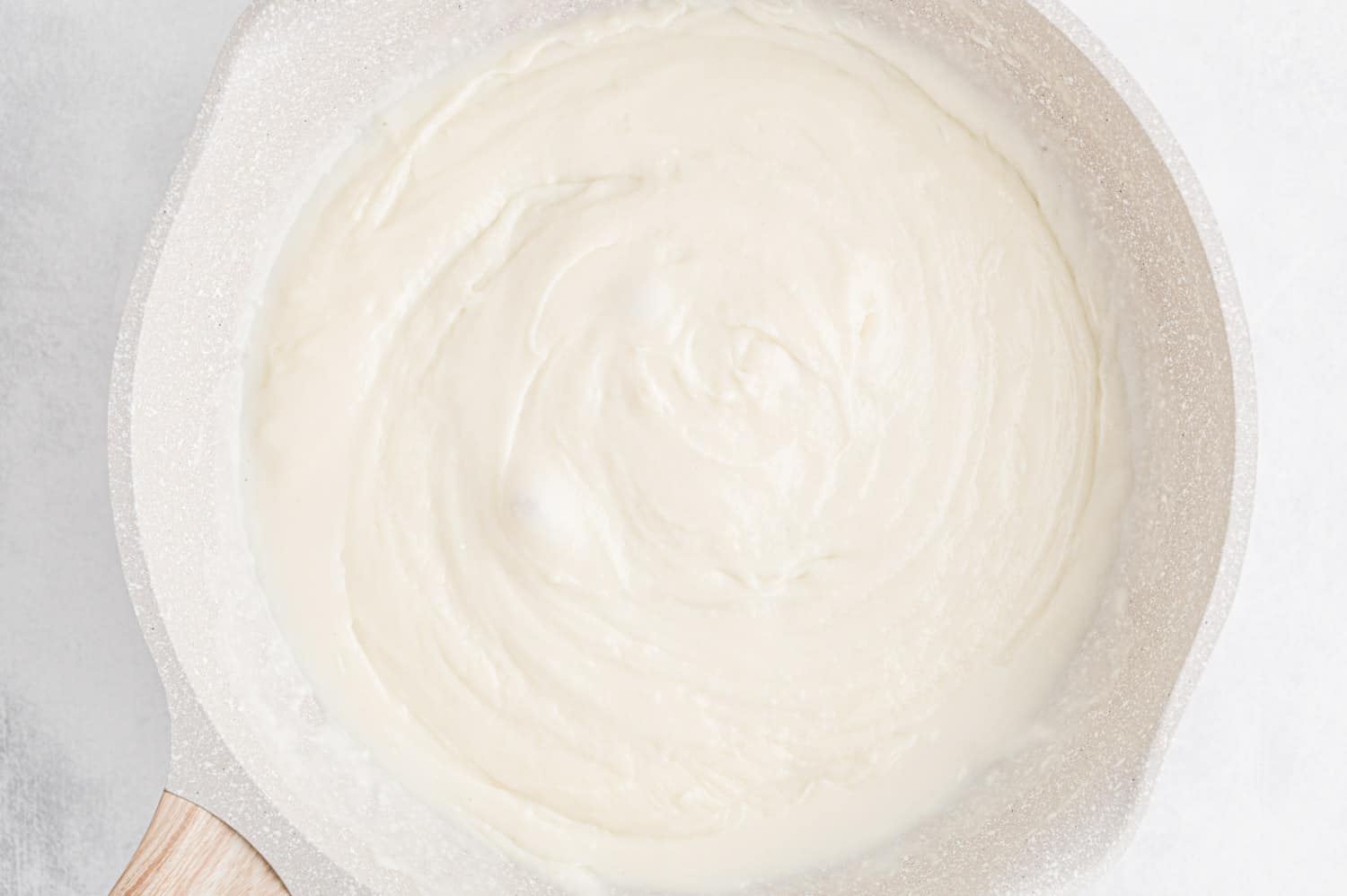 White colored queso in a white pan.