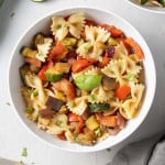 Bowl of pasta salad with bowtie pasta and grilled vegetables.