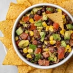Overhead view of black bean, avocado, and corn salad with tortilla chips.