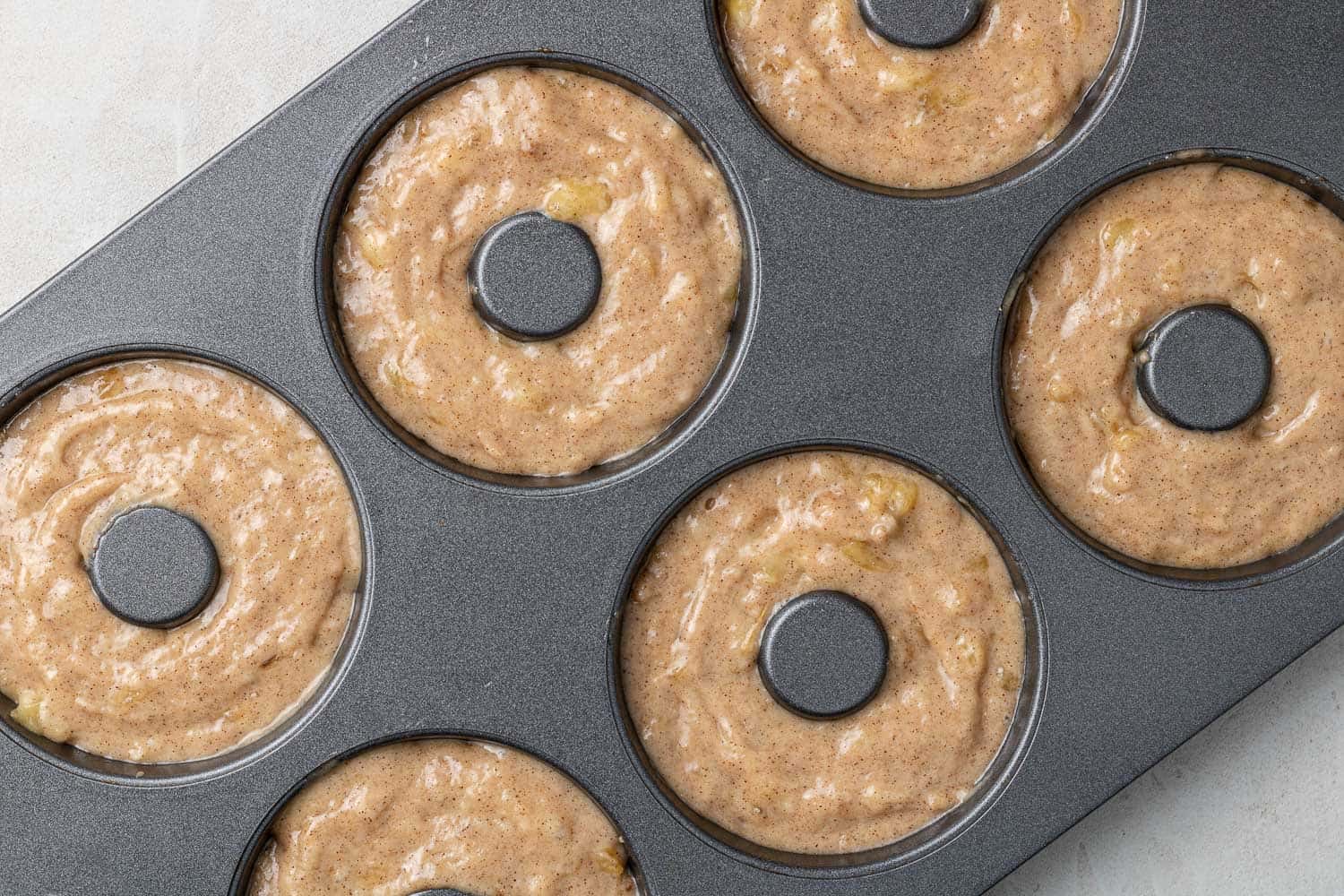 Unbaked donuts in donut pan.