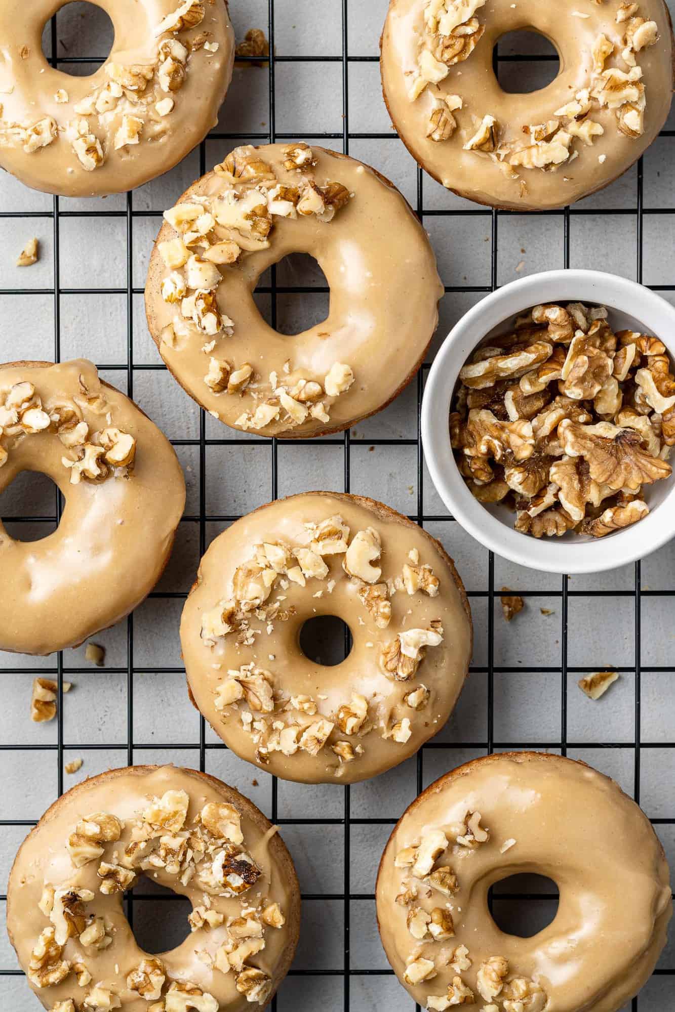 Glazed donuts topped with nuts.