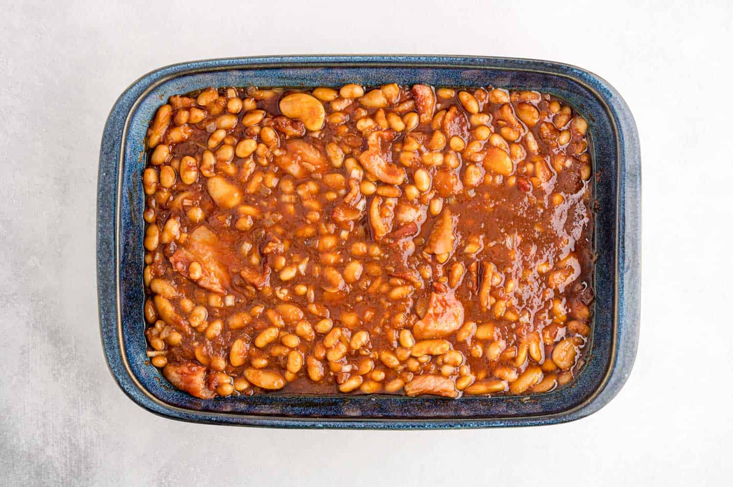 Uncooked beans in a blue casserole dish.