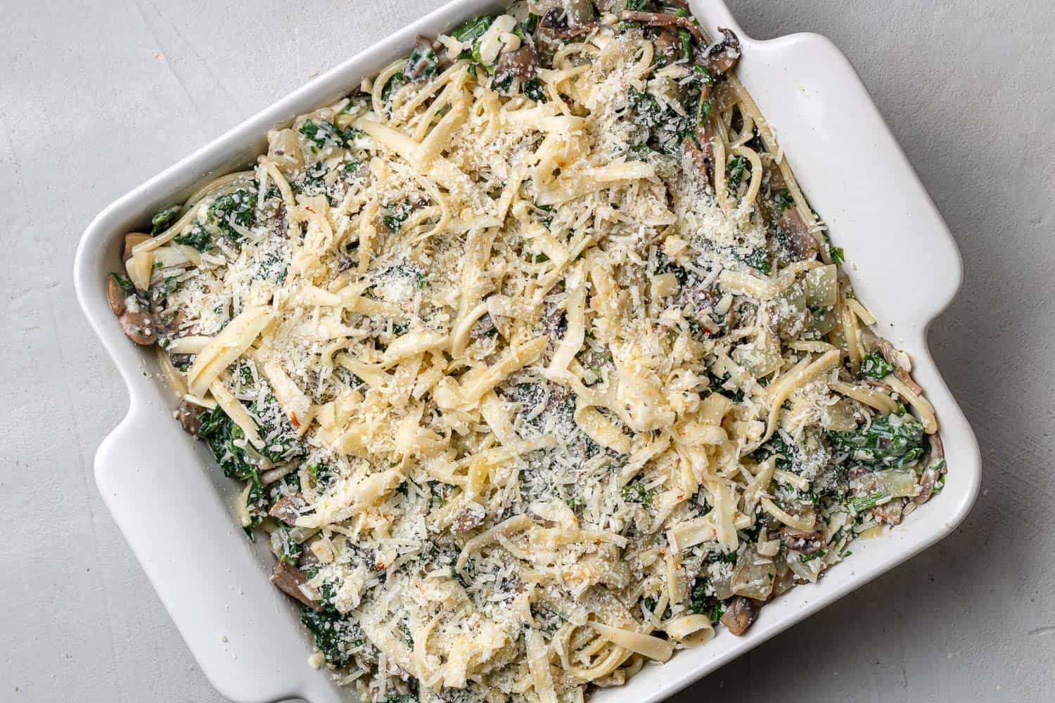 Spinach spaghetti topped with cheese.