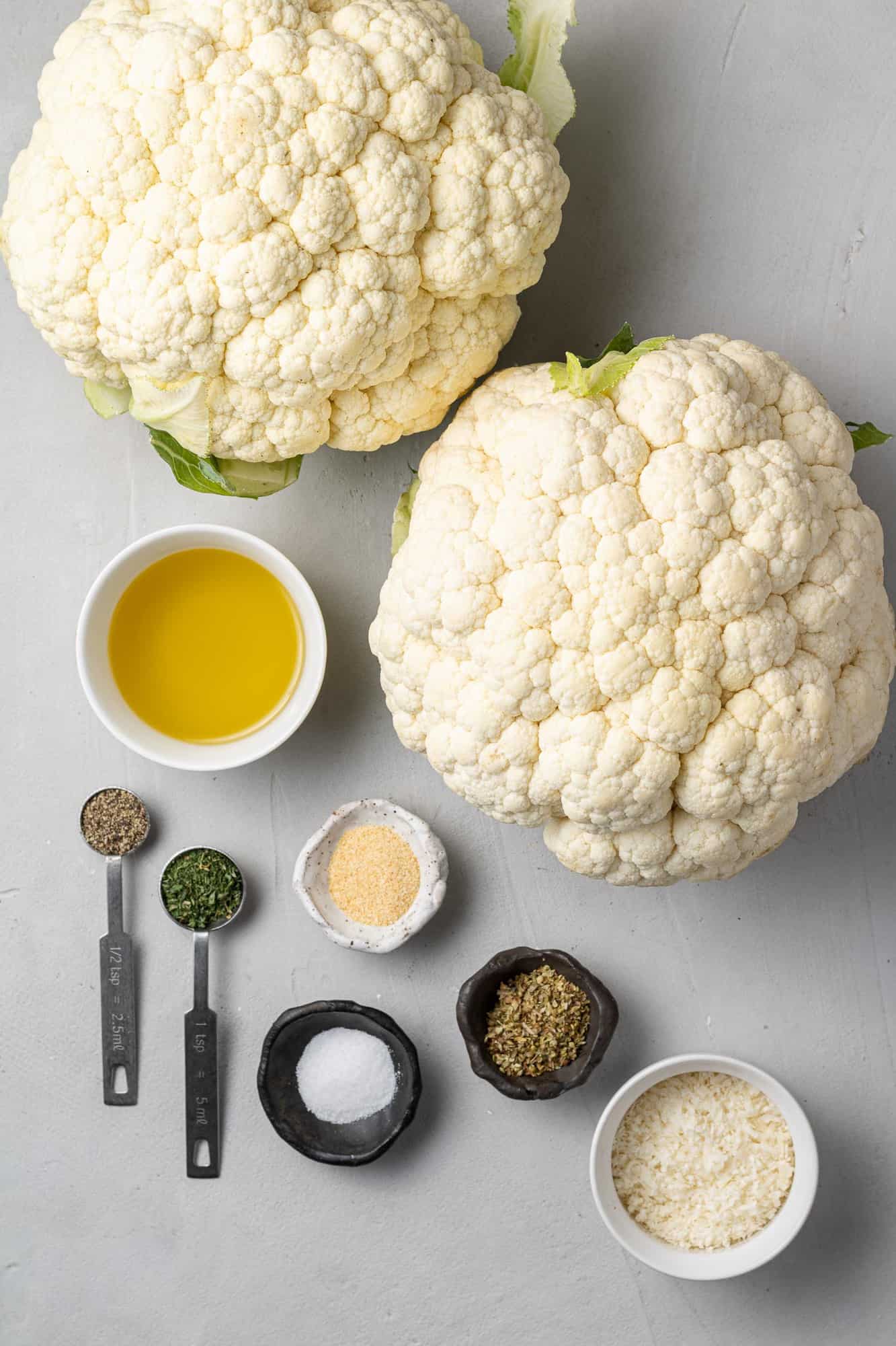 Overhead view of ingredients needed for recipe, including two heads of cauliflower.