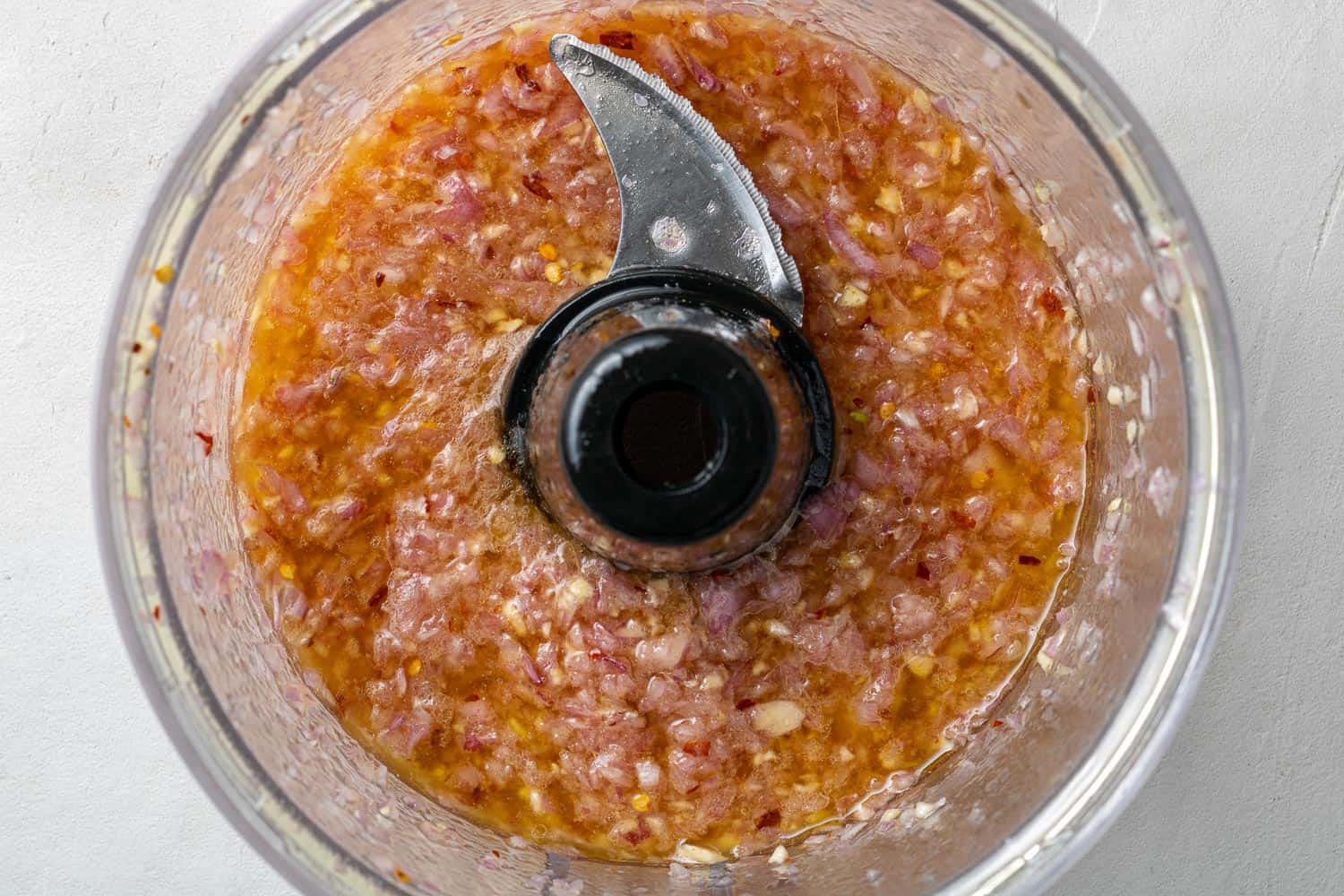 Olive oil, shallot, and garlic in a food processor.